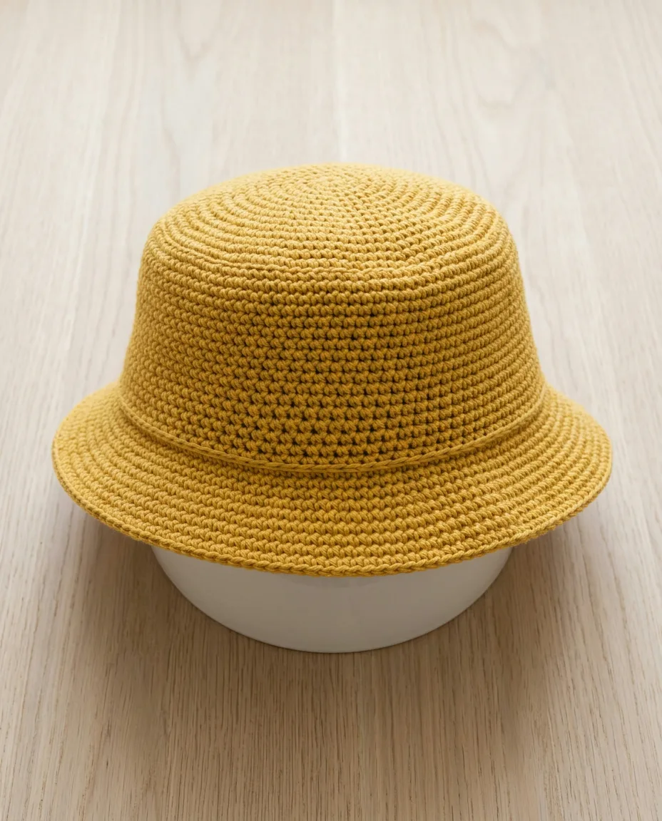 The hat resting on an upturned bowl, the way it dries, with the brim standing out level from the fold line.